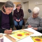 Mary Anderson showing watercolor techniques to students